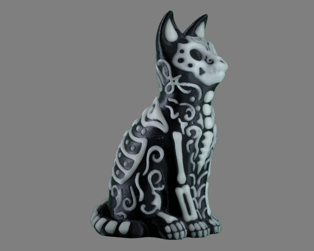 Photo of 3D printed sugar skull cat in glow-in-the-dark green design on black